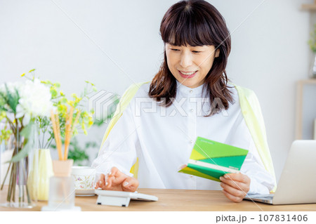 通帳を見る主婦 通帳を見る主婦 107831406