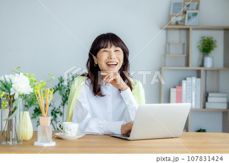 リビングでパソコンを使う女性 リビングでパソコンを使う女性 107831424