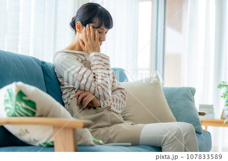 体調不良で頭を抱える中年女性 体調不良で頭を抱える中年女性 107833589