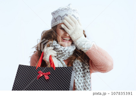 excited stylish woman in sweater, mittens, hat and scarf 107835391