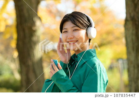 秋晴れの公園で音楽を楽しむ女性 秋晴れの公園で音楽を楽しむ女性 107835447