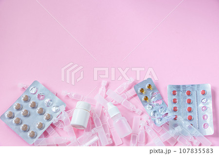 Medications and medical ampoules on pink background. Medications and medical ampoules on pink background. 107835583