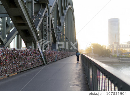 People walk across the Hohenzollern Bridge, Cologne 107835904