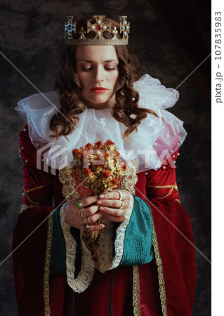 medieval queen in red dress with dried flower and white collar medieval queen in red dress with dried flower and white collar 107835983