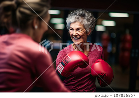 Age-Defying Strength A Senior Woman Boxer, Showcasing Vitality and Resilience, Engages in Training with Her Coach, Confidently Breaking Stereotypes Through Active Exercise. created with Generative AI 107836857