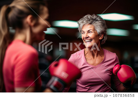 Age-Defying Strength A Senior Woman Boxer, Showcasing Vitality and Resilience, Engages in Training with Her Coach, Confidently Breaking Stereotypes Through Active Exercise. created with Generative AI 107836858