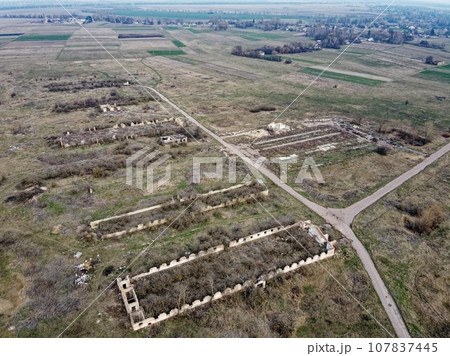 Destroyed agricultural buildings, aerial view. Abandoned livestock farm. Destroyed agricultural buildings, aerial view. Abandoned livestock farm. 107837445