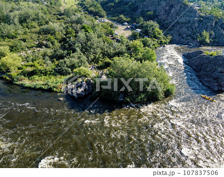 A bend of the Southern Bug river called Integral from a bird's eye view. A picturesque river among the rocky terrain. 107837506