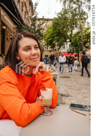 beautiful woman at outside cafe drinking coffee 107838754