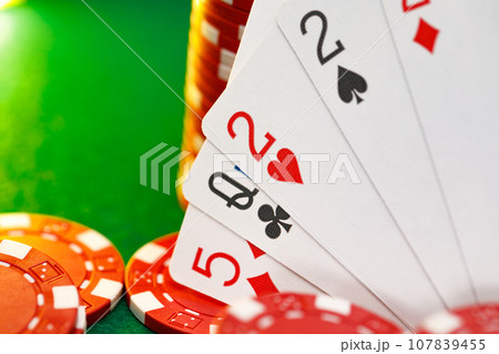 Red playing chips and cards on poker table Red playing chips and cards on poker table 107839455