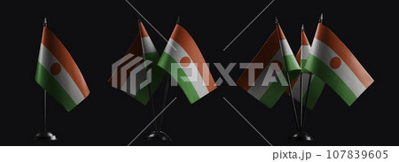 Small national flags of the Niger on a black background 107839605