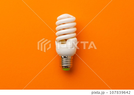 Light bulb on bright orange background top view 107839642