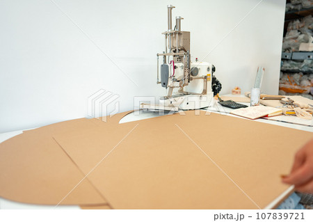 Seamstress working with fabric in sewing factory close up 107839721