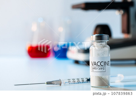 Covid-19 vaccine bottle with a syringe on lab table Covid-19 vaccine bottle with a syringe on lab table 107839863