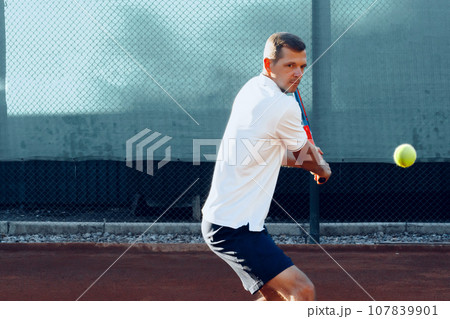 Proffesional tennis player beats off a ball during match Proffesional tennis player beats off a ball during match 107839901