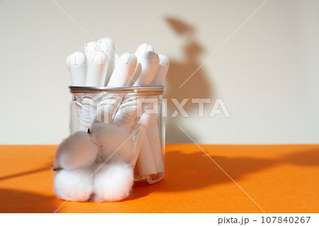 Glass jar with hygienic tampons and cotton flower Glass jar with hygienic tampons and cotton flower 107840267