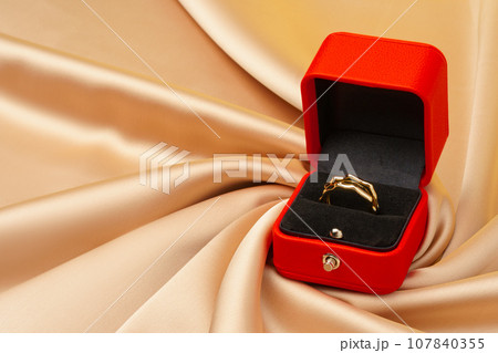 Golden ring in red jewelry box close up 107840355