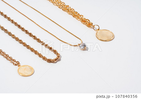 Set of gold chains with pendant on white background 107840356