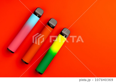 Disposable electronic cigarettes on red background close up Disposable electronic cigarettes on red background close up 107840369