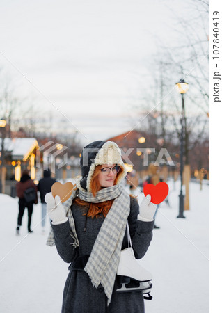 young beautiful woman is holding red card in form of heart, Valentine's day 107840419