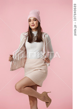 Happy playful young woman in pink hat, shirt and skirt Happy playful young woman in pink hat, shirt and skirt 107840689
