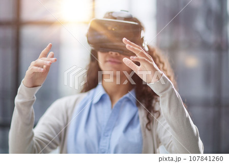 positive woman wearing virtual reality goggles headsetConnection, technology, new generation, progress concept. 107841260