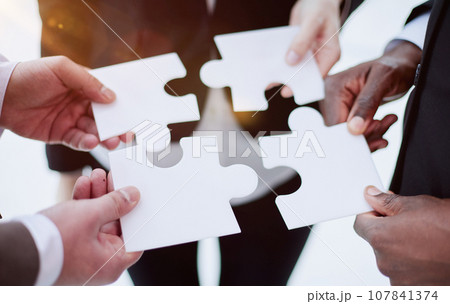 Group of business people assembling jigsaw puzzle and represent team support and help concept 107841374