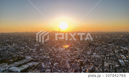 「千葉県」江戸川矢切付近から夕暮れのオレンジ色に染まる街並みをドローンで望む 107842768