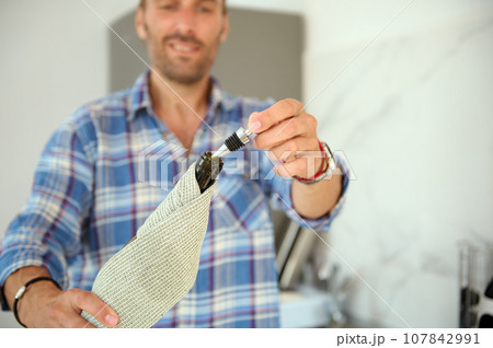 Close-up hands of smiling man holding bottle of wine. Holidays. Celebration of festive life events. Anniversary. Dating 107842991