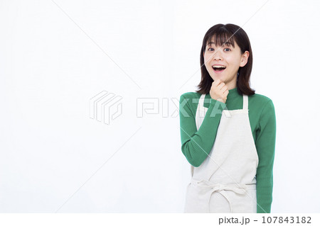 白い背景の前で笑顔でビックリしている30代の主婦 白い背景の前で笑顔でビックリしている30代の主婦 107843182