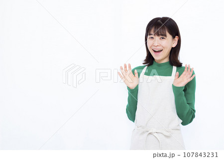 白い背景の前で笑顔でビックリしている30代の主婦 107843231
