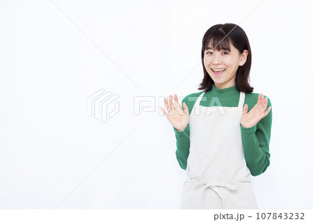 白い背景の前で笑顔でビックリしている30代の主婦 107843232