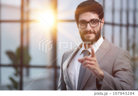 Successful businessman confidently looks at the camera and warns about something Successful businessman confidently looks at the camera and warns about something 107843284
