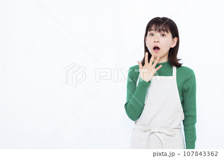 白い背景の前でビックリしている30代の主婦 107843362