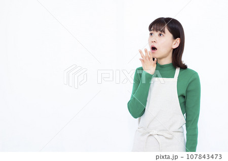 白い背景の前でビックリしている30代の主婦 107843473