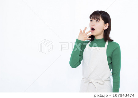 白い背景の前でビックリしている30代の主婦 107843474