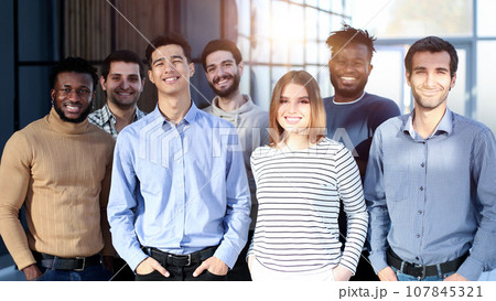 Businessmen posing in office lobby after meeting 107845321