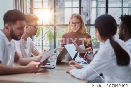 Team Working At Desks In Busy Office 107846466
