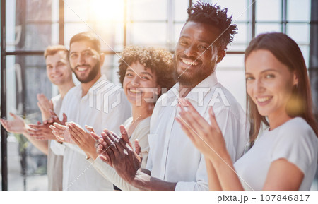 Group of businesspeople sitting in a line and applauding. Group of businesspeople sitting in a line and applauding. 107846817