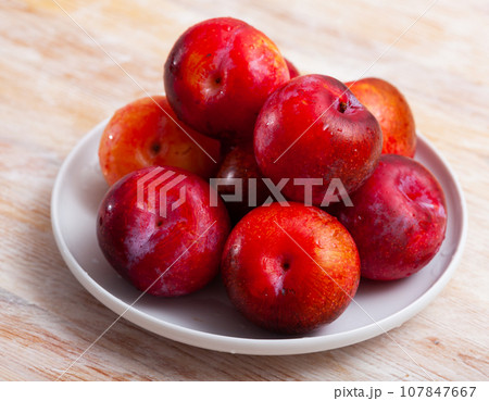 Fresh red plums in plate Fresh red plums in plate 107847667