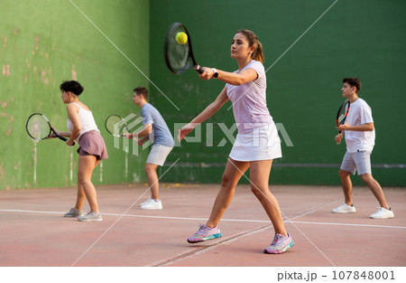 Expressive resolved fit girl playing frontenis ball friendly match on court Expressive resolved fit girl playing frontenis ball friendly match on court 107848001