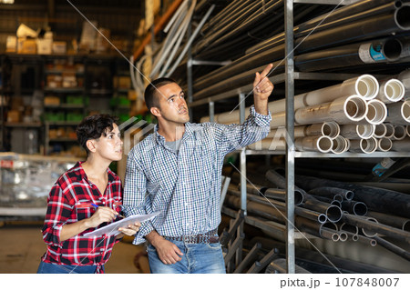 Woman and man dicsussing stock control in warehouse 107848007