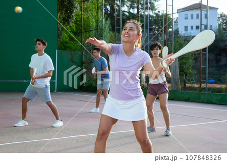Young Argentinian woman playing pelota at open-air fronton in summer 107848326