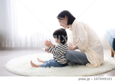 子どもと一緒にスマホを見る母親 子どもと一緒にスマホを見る母親 107849101