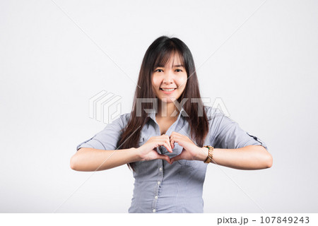 Woman smiling confidence make finger heart gesture figure symbol shape sign with two hands isolated white background, Asian happy portrait beautiful young female send love and happy valentine 107849243