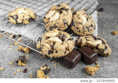 chocolate cookies Fresh organic homemade cookies with chocolate chips and dried berries on parchment paper chocolate cookies Fresh organic homemade cookies with chocolate chips and dried berries on parchment paper 107849993