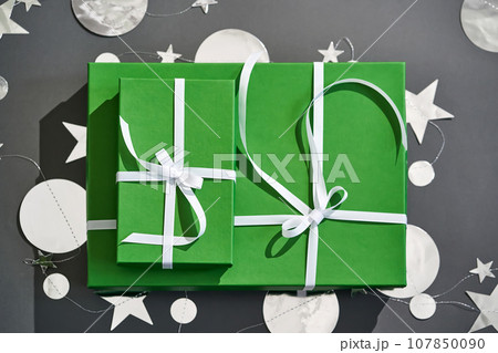 Green boxes with gifts on a gray. 107850090