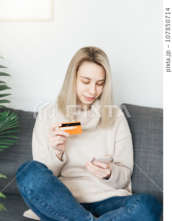 Young woman holding smartphone and banking credit card 107850714