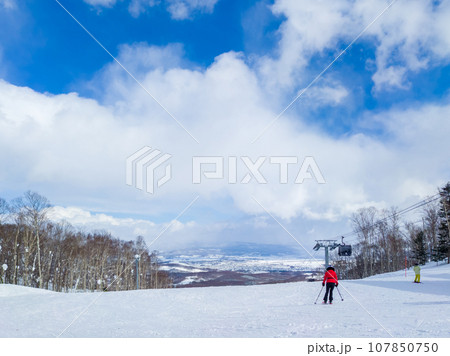 閑静な広いゲレンデを滑るスキーヤー (北海道、ニセコ) 107850750