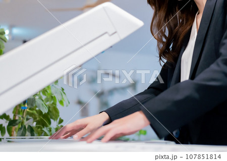 プリントしたドキュメントを確認する若い女性 107851814